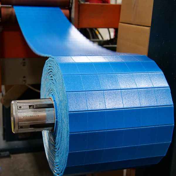 die-cutting blue PVC foam parts on adhesive backing